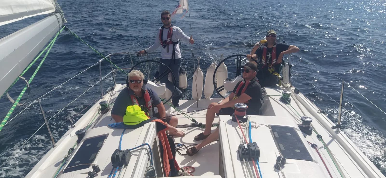 Membre d'équipage à la barre, équipage réuni dans le cockpit sous le soleil