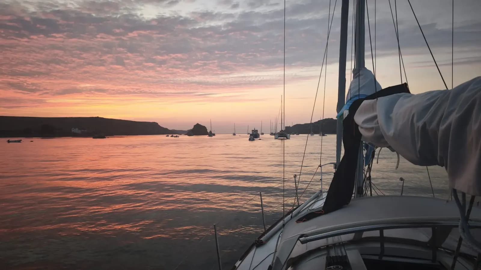 Coucher de soleil rose sur le mouillage, vu depuis le pont du voilier